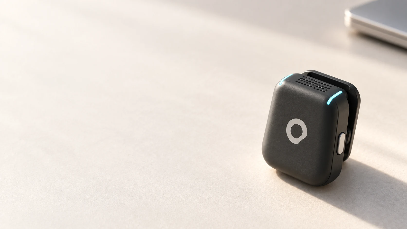 A graphite aecoo microphone on a warm white desk